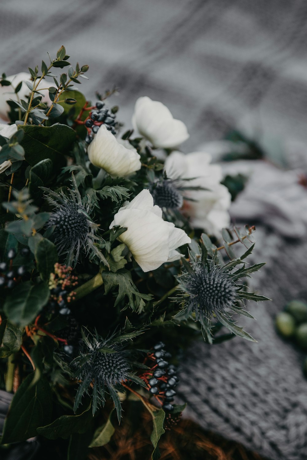 A white flower arrangement resting on a soft blanket
